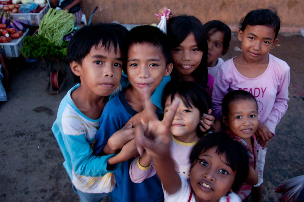 several children pose for a picture at a market