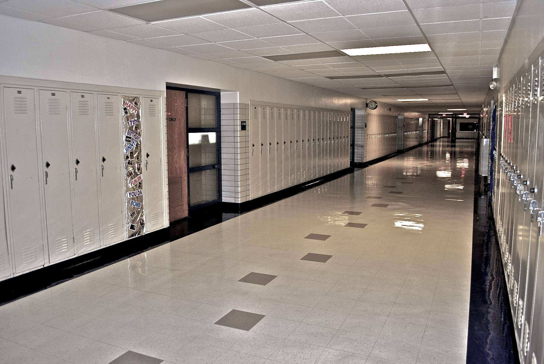 a long, empty hallway with multiple lockers