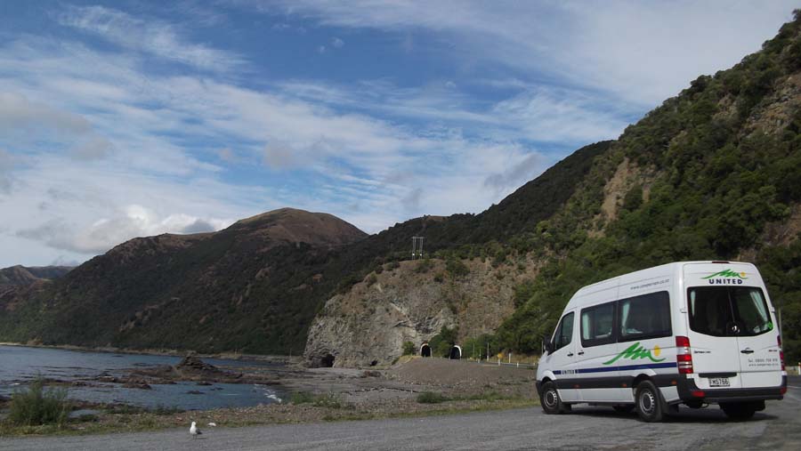 a camper van parked on a road near a mountain side