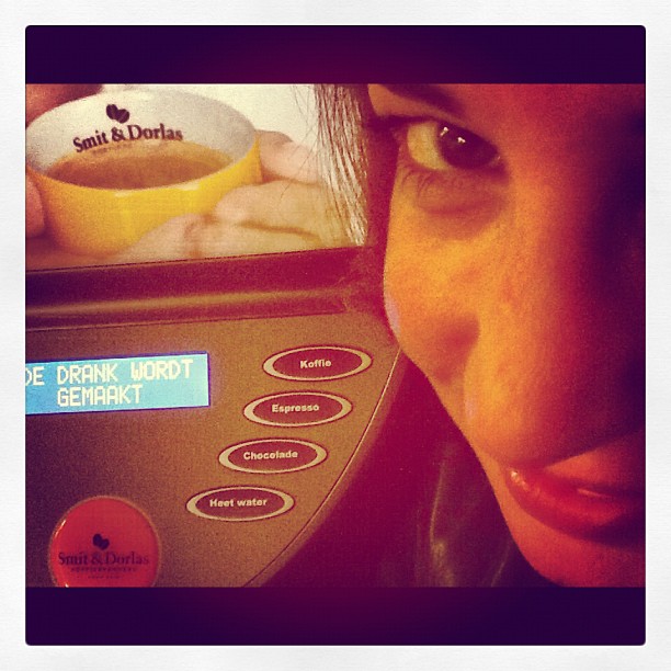 a woman looking at a microwave in a kitchen