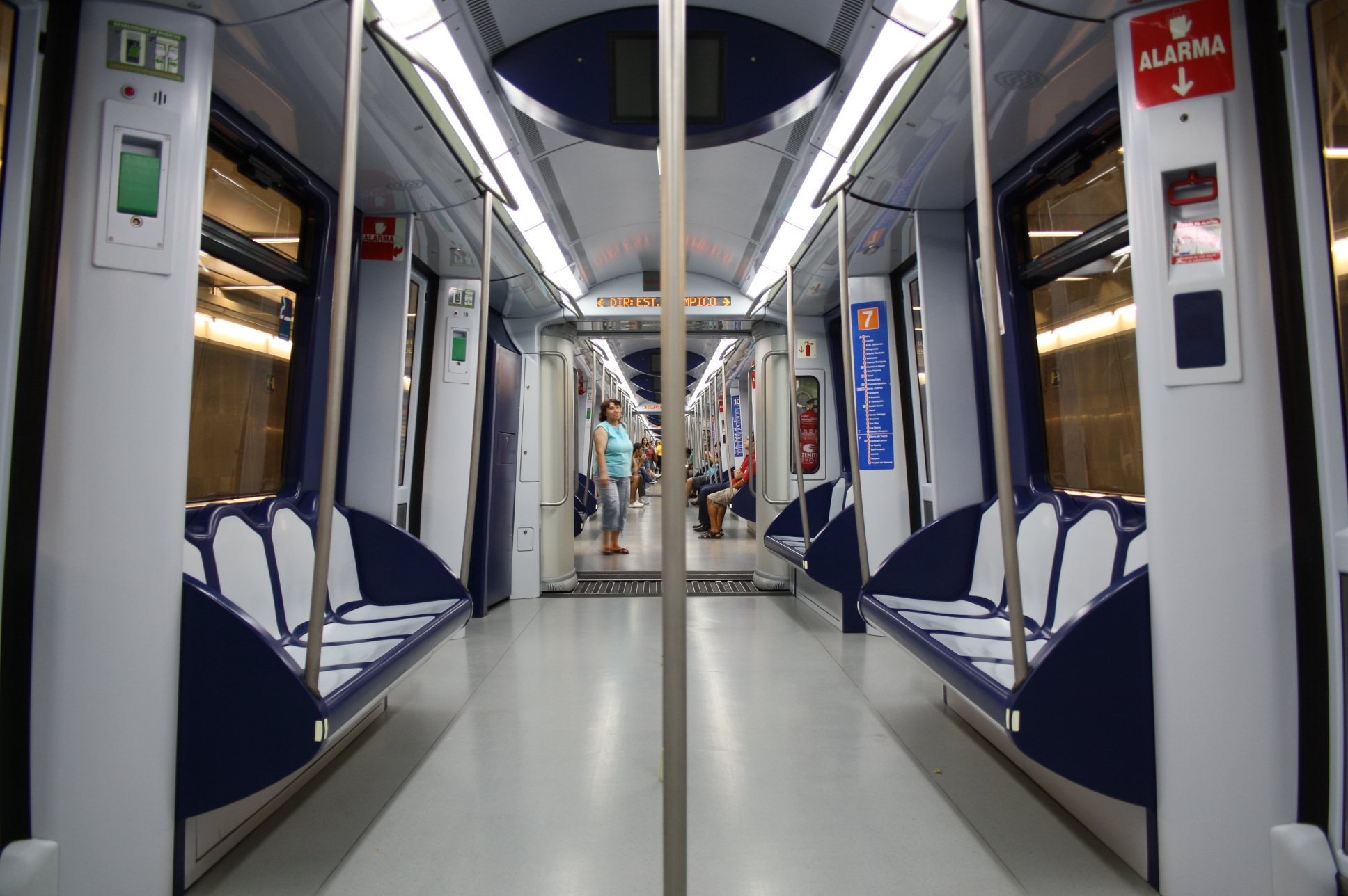 blue and white seats on a train with one light