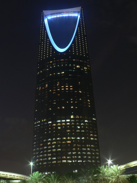 the top of a very tall building with a lighted sign