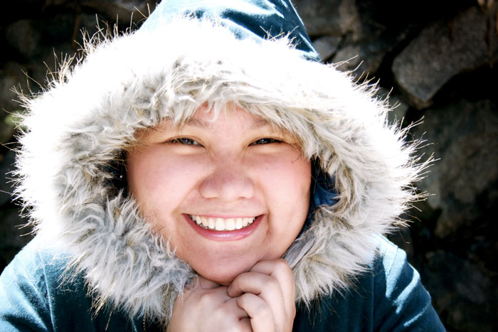 a woman in a hooded jacket and hood with her hands together