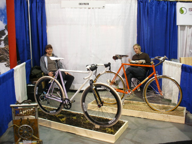 two people sitting on wooden crates with bicycles