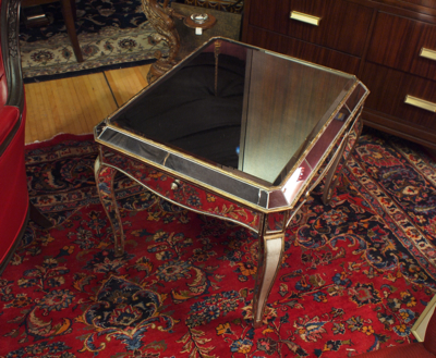 a silver table sits on a red carpet and ornate furnishings