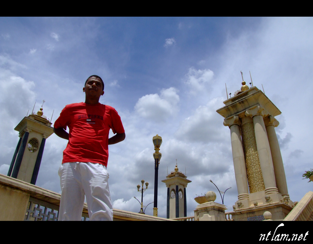 a man standing outside in white and red clothing