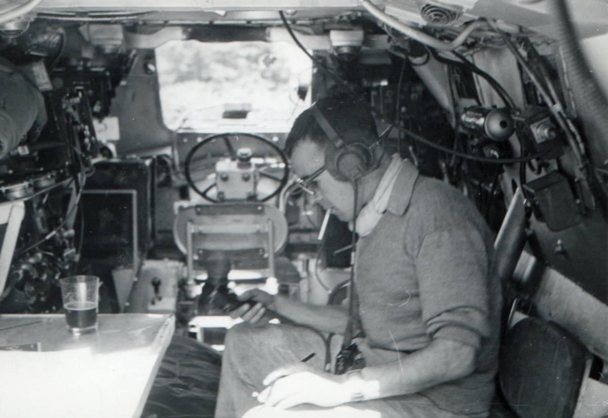 the cockpit area of a small airplane with two men sitting at a table and writing