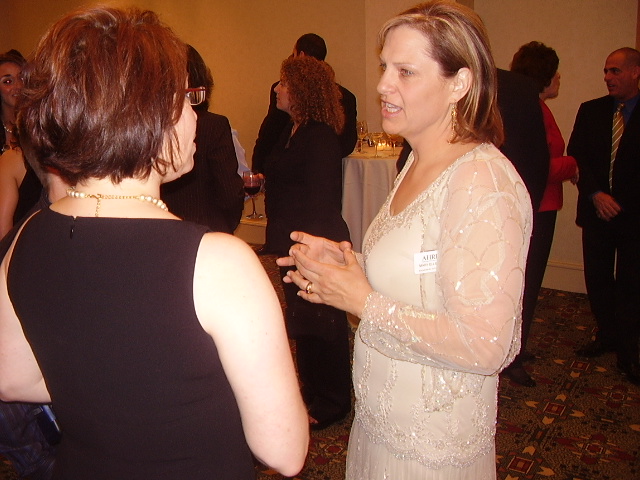 some women are talking to each other at an event