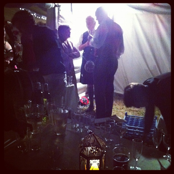 a group of people standing around a table next to wine glasses