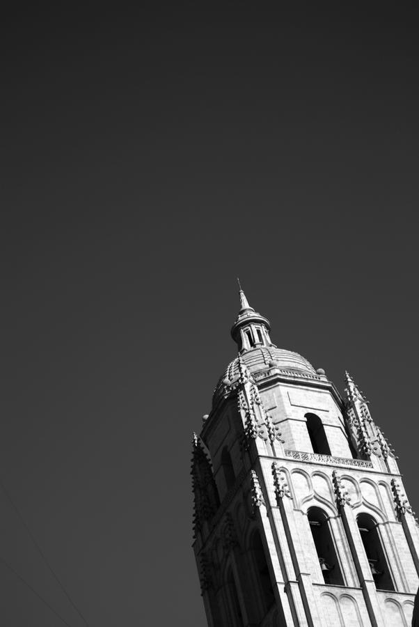 an ornate tower in black and white with power lines across from it