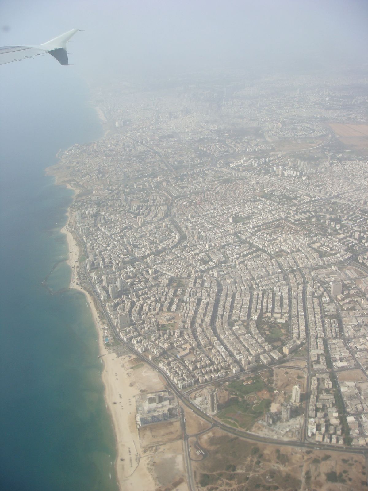 an aerial view of a city with beach and ocean