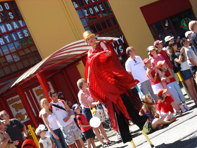 an person is in front of some storefronts wearing a red and black costume