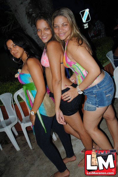 three young women standing side by side at a pool party