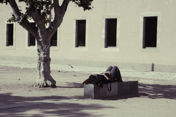 a person laying on the ground while a tree is growing