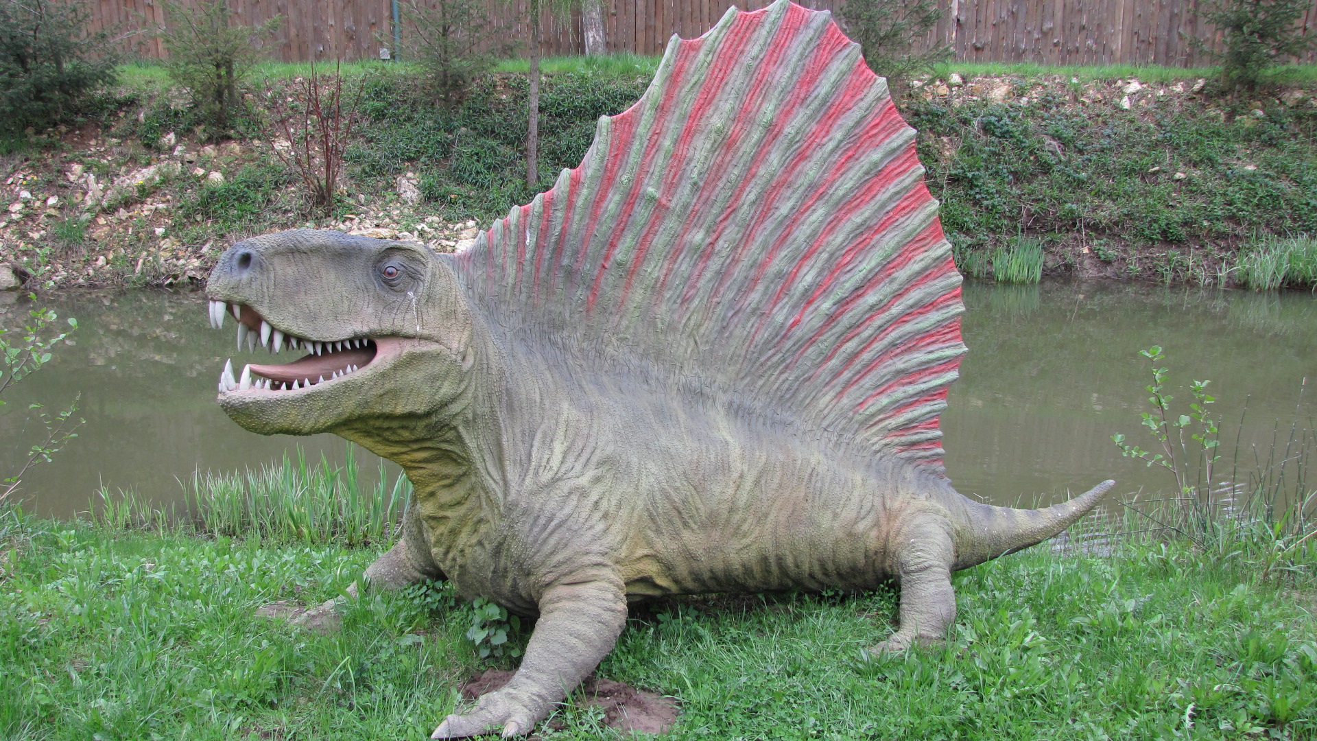 an adult dinosaur with its mouth open and its tail curled back