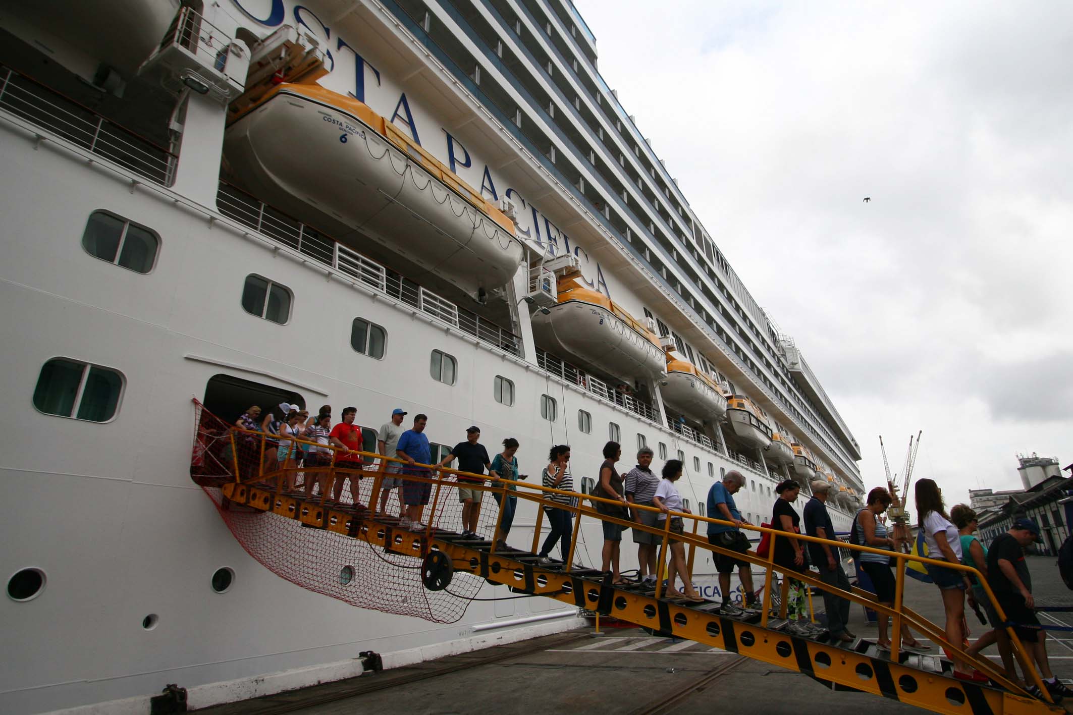 people lined up to board a cruise ship
