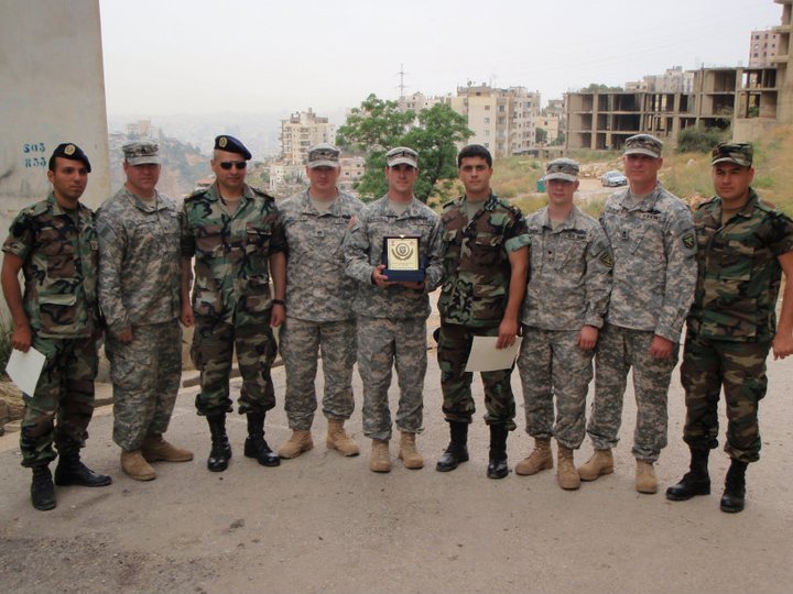 soldiers posing for a po holding an award