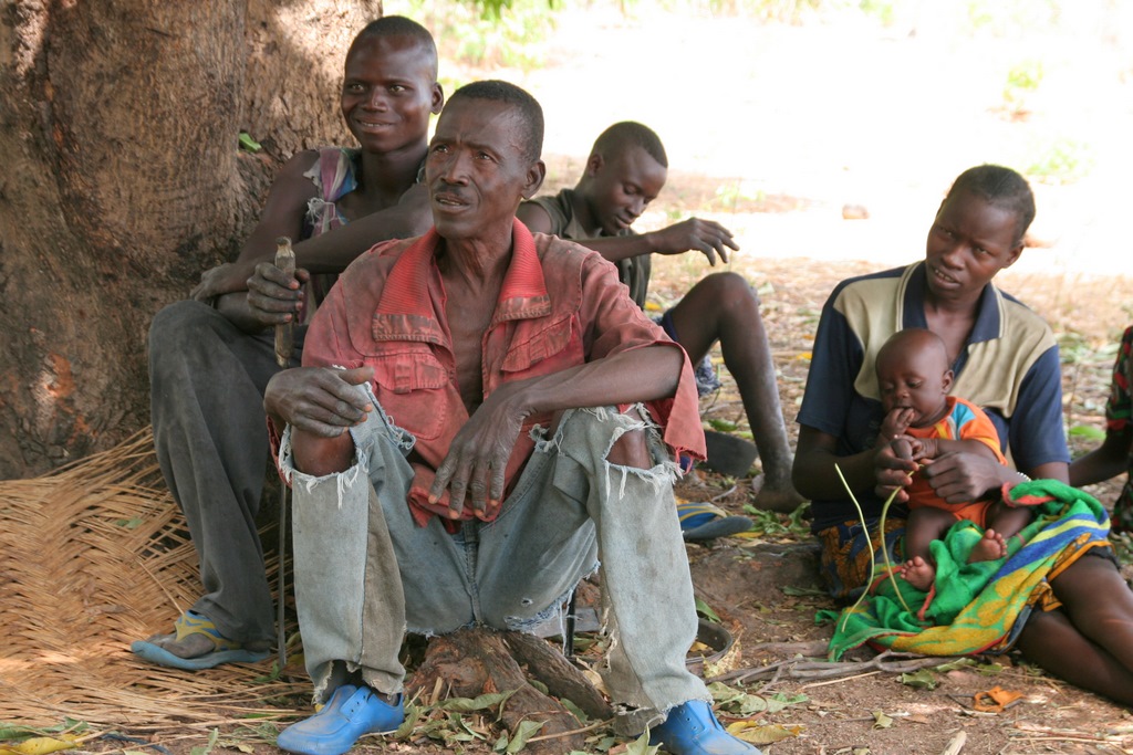 a couple of s sit in front of a group of men