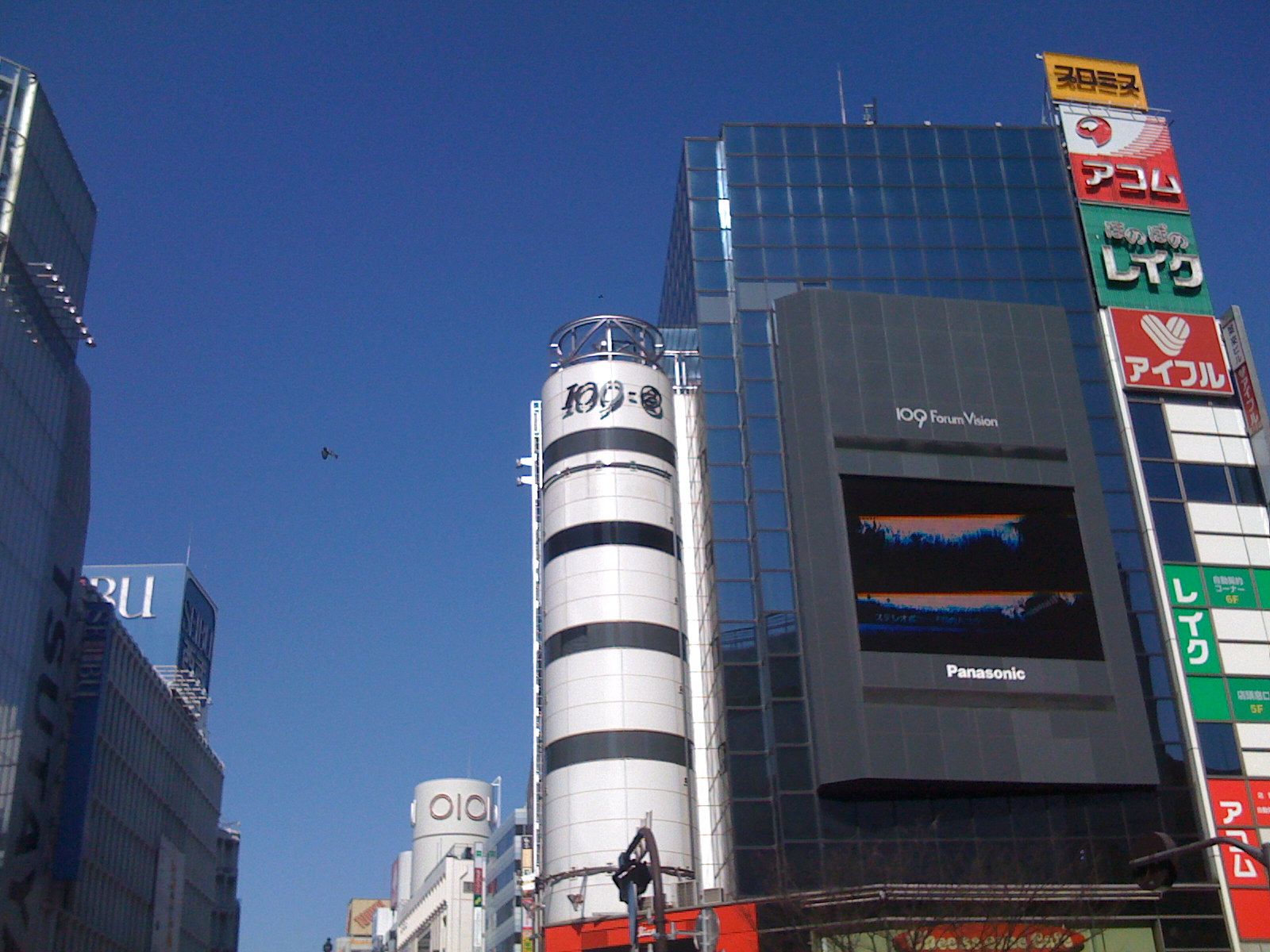 a big tower is on the side of a tall building in a city