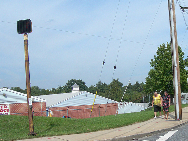 a couple of people standing near a cross walk