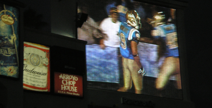 a large screen that shows two football players talking to each other