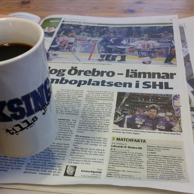 a cup of coffee is sitting on the newspaper