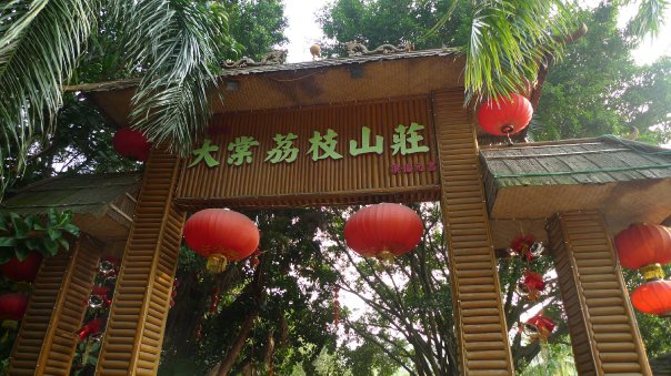a tall wooden arch with red lanterns hanging over it