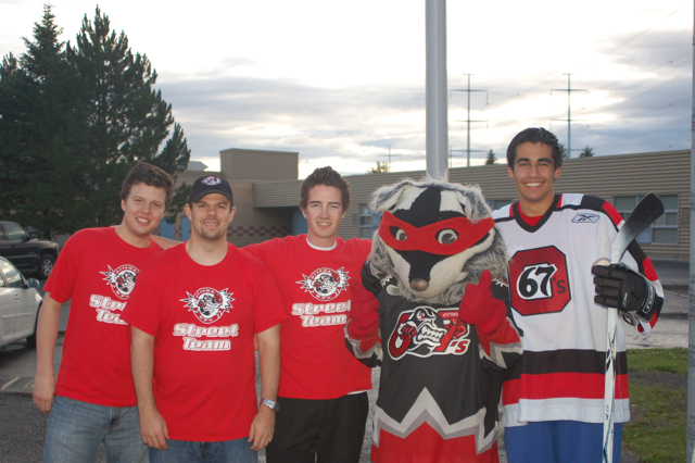 two men and three other men in costume posing with mascot