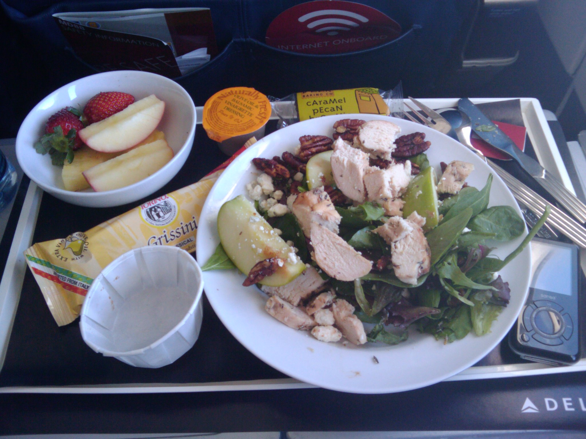 a tray that has a plate of fruit and salad on it