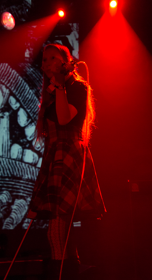 a young woman standing on stage with microphone