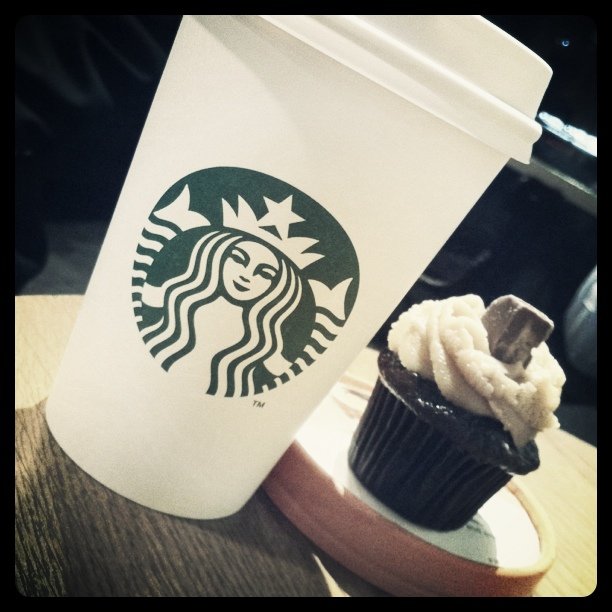 a cupcake and a starbucks drink on a table