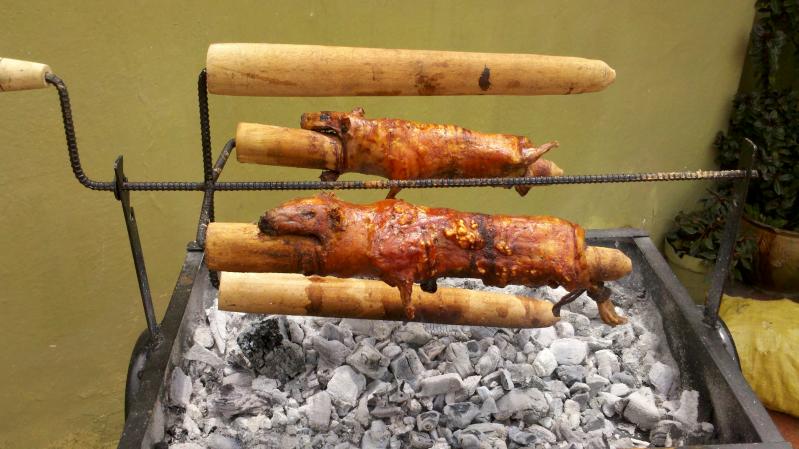 two large wooden sticks in a grill, with meat in them