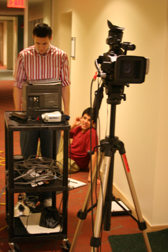 there are cameras sitting in a room and a man on the floor is standing near a television