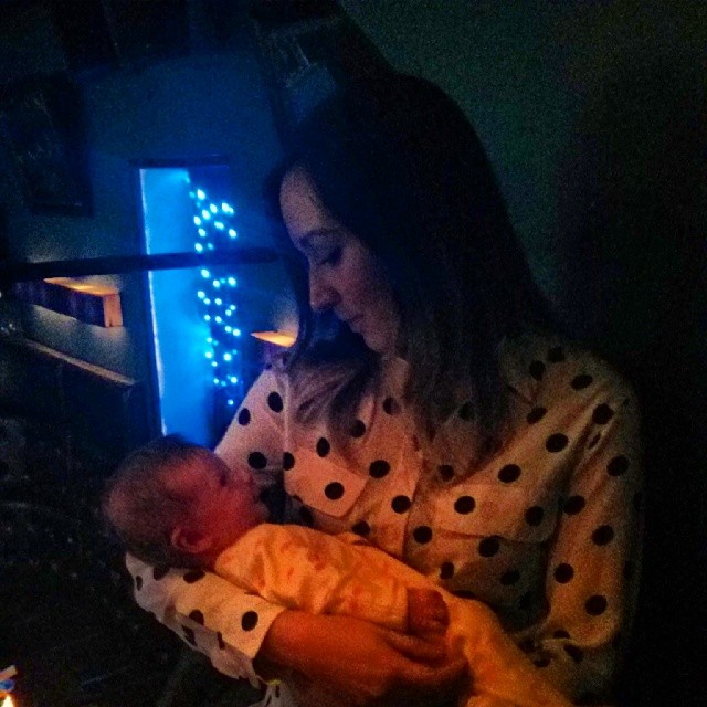 a woman holding a baby in her arms at night