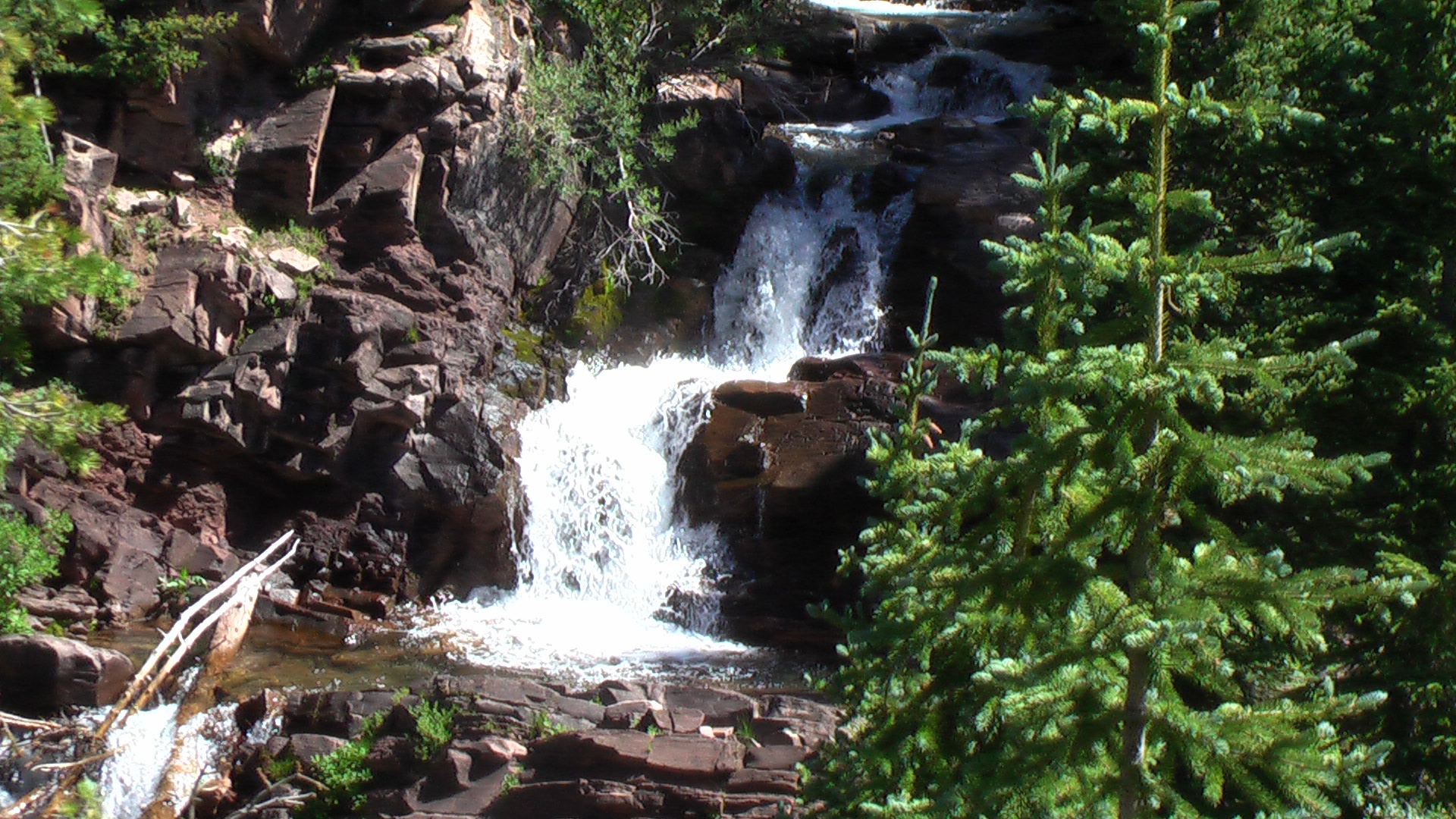 a small waterfall is coming out from the mountains