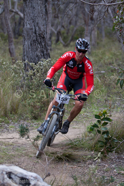 a man riding a bicycle down a dirt trail