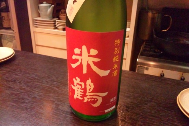 this is a bottle of sake next to a plate