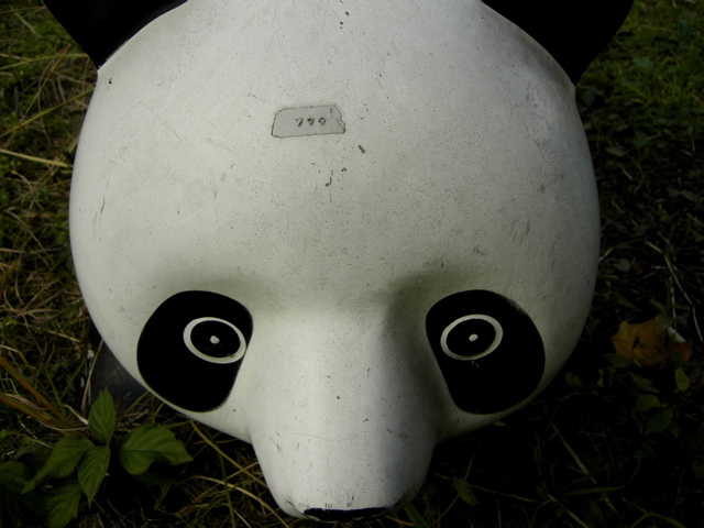 the panda mask is on the ground near grass