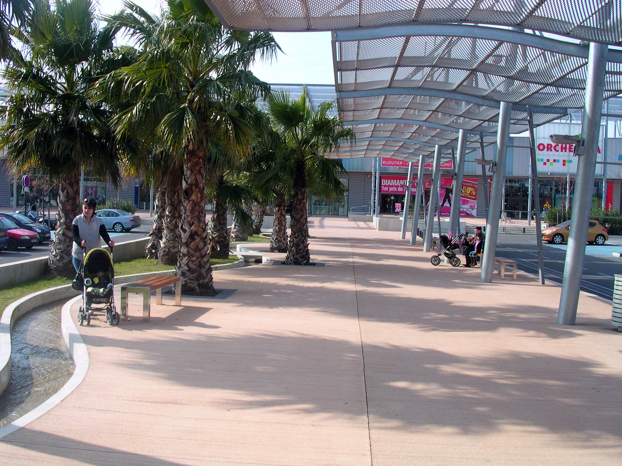 a large long covered area with some palm trees