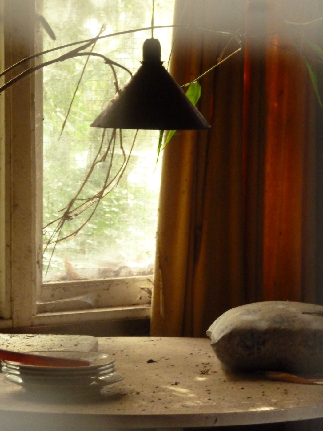 a table topped with plates next to a window