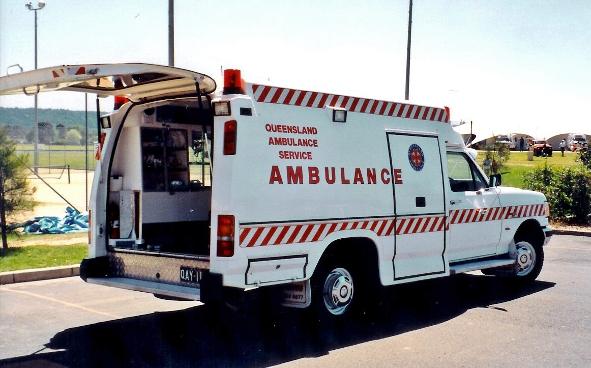 ambulance with open doors parked on side walk