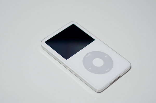 an ipod on a table with an empty white case