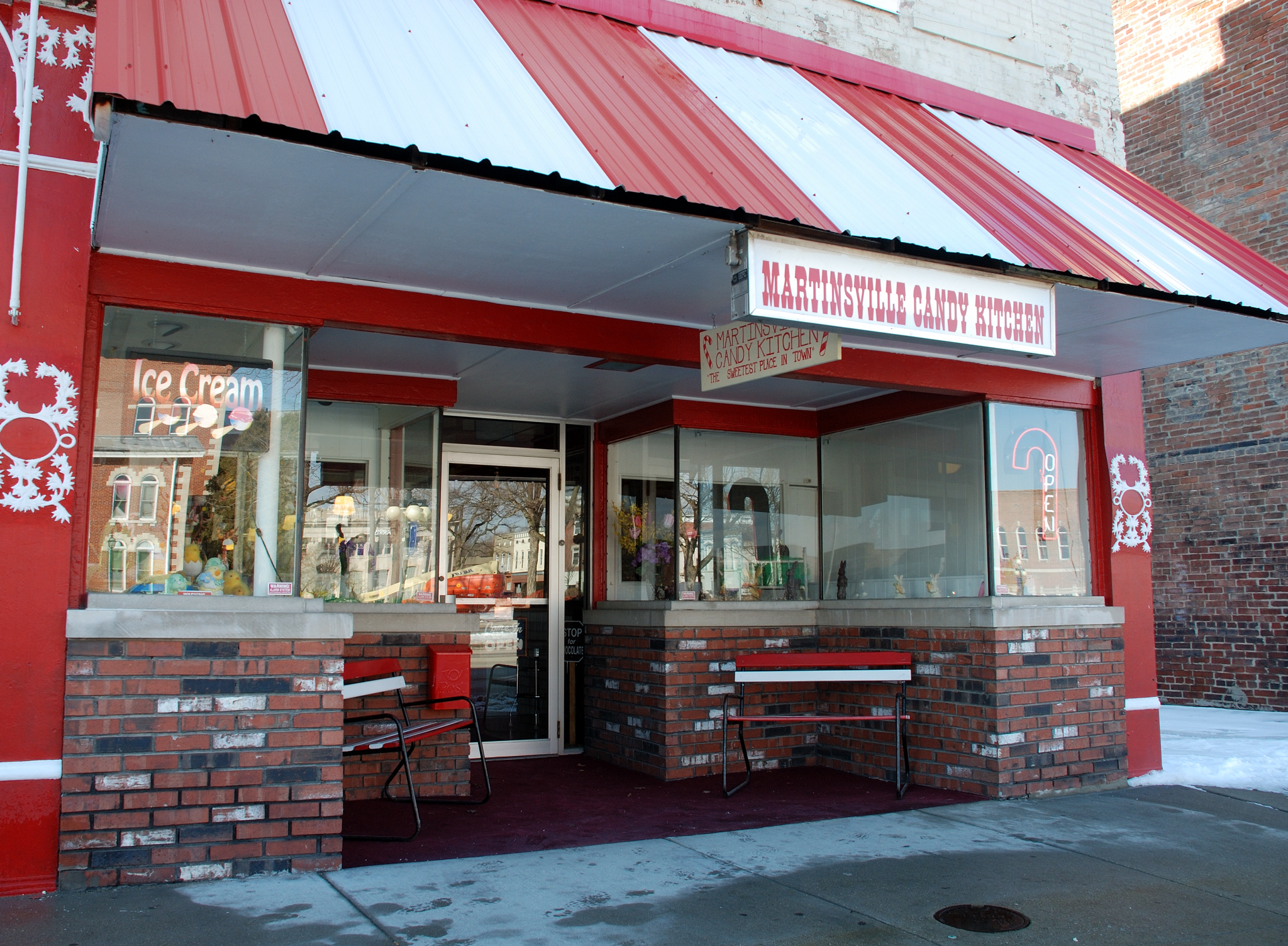 an open restaurant with a snow covered sidewalk