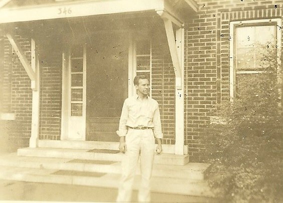 an old pograph of a man in front of a house