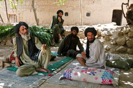 people sitting around with some blankets on the ground