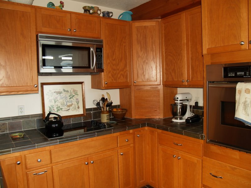 a kitchen has some wooden cabinets and appliances