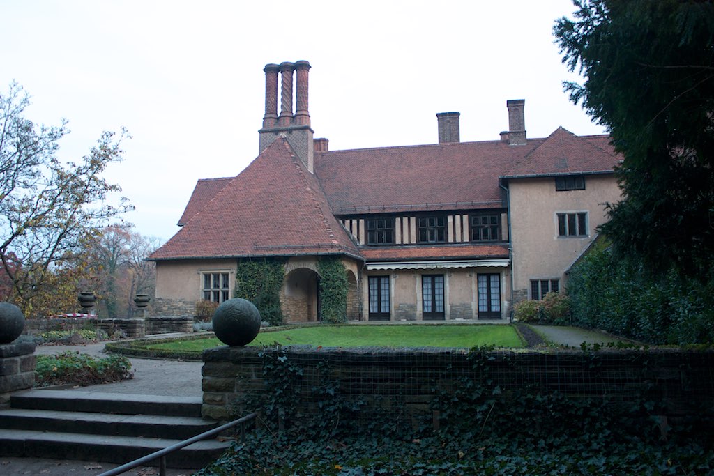 an old style mansion with a large garden in front of it