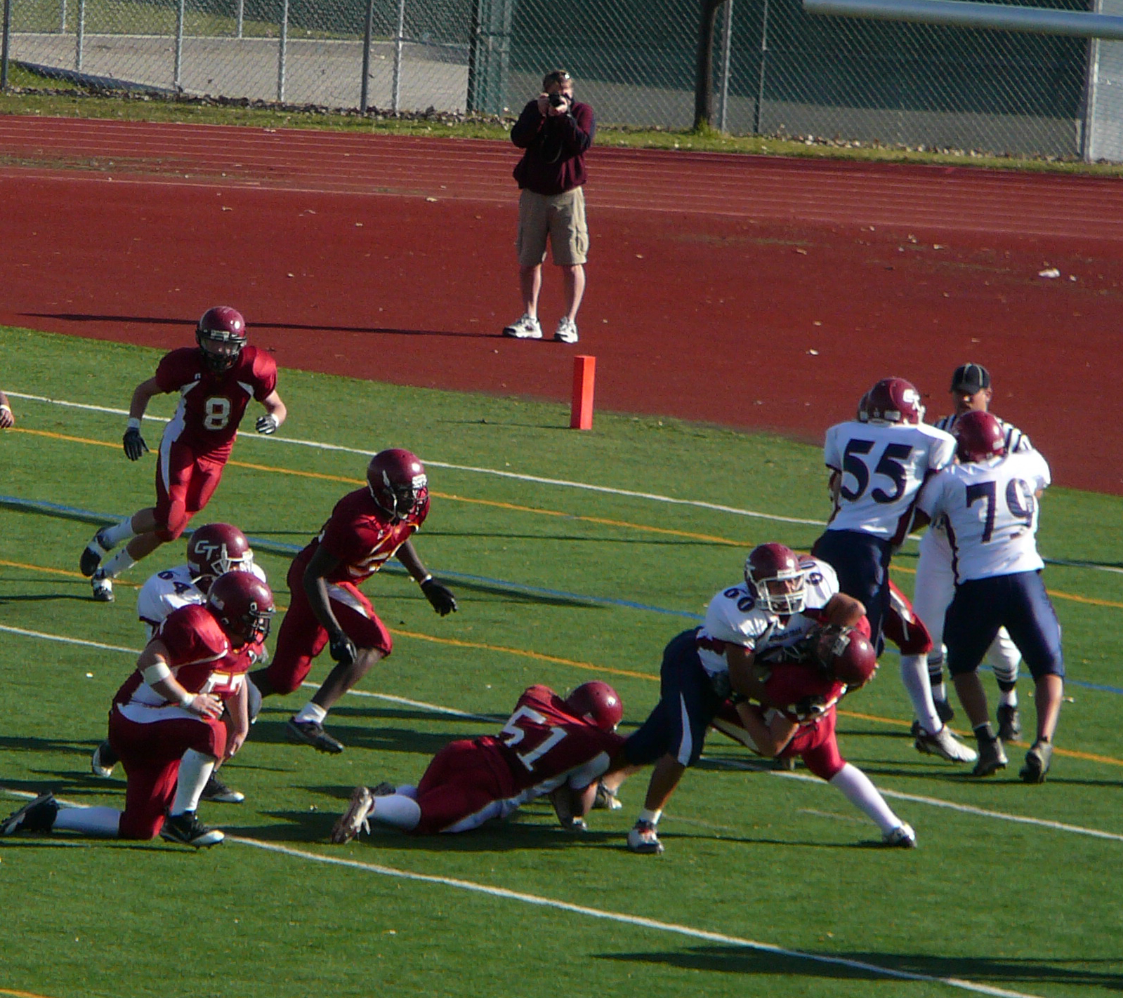 people playing football, as an individual jumps and runs with the ball