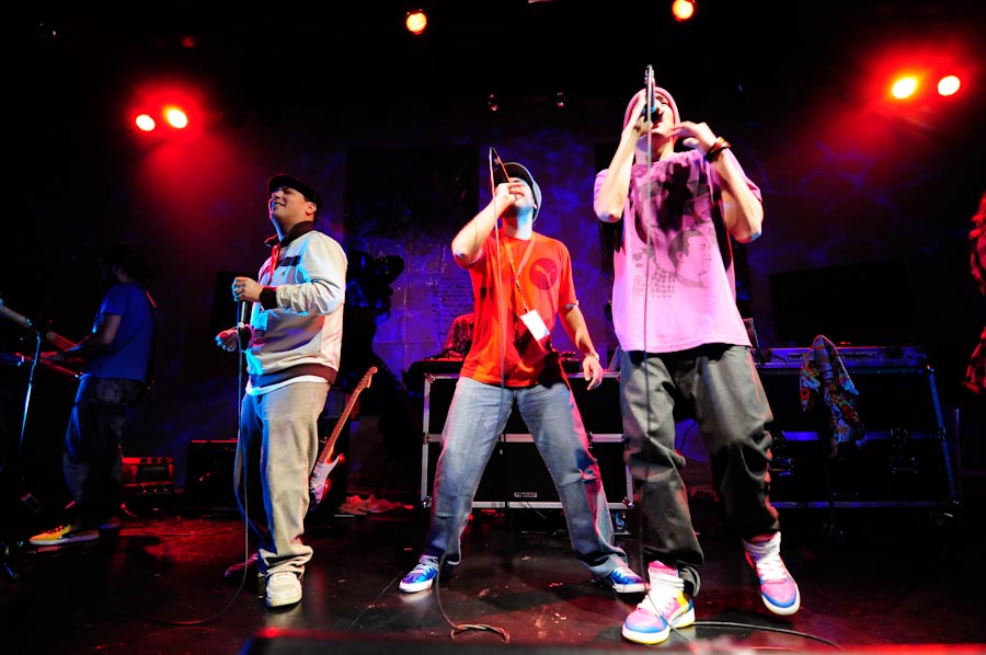 some young men on a stage singing and holding their phones