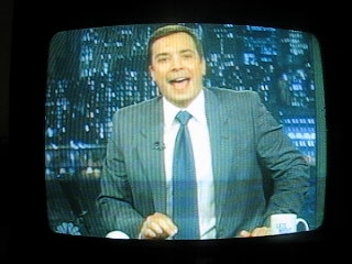 a man in a business suit talking on a television